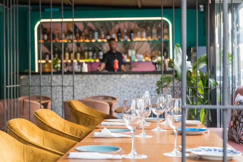 A restaurant interior with a bar area, wooden chairs, and a table set for dining. 2