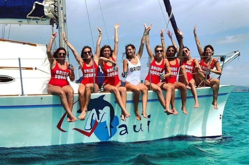 A group of people on a boat with 'BRIDE SQUAD' written on their swimsuits. 5