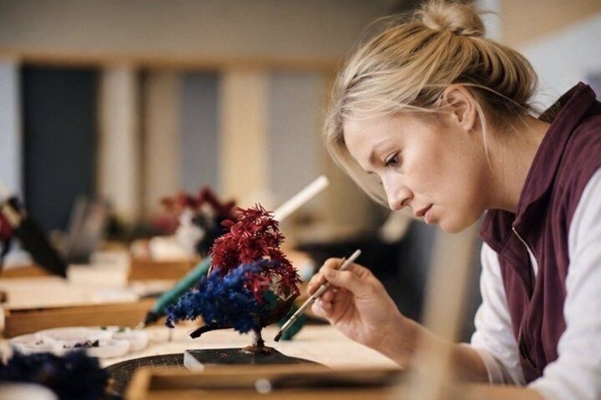 A person painting a colorful bird on a canvas. 1