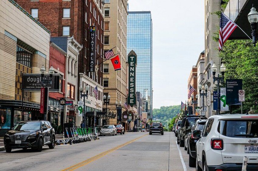 A city street lined with buildings, including a hotel and a Tennessee sign. 4