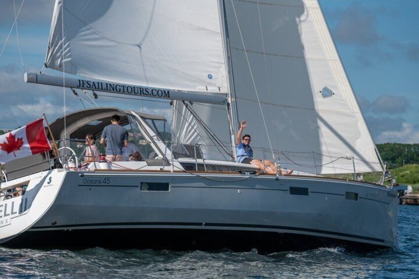 A sailboat with a Canadian flag, named 'Ocean 45,' on the water. 2
