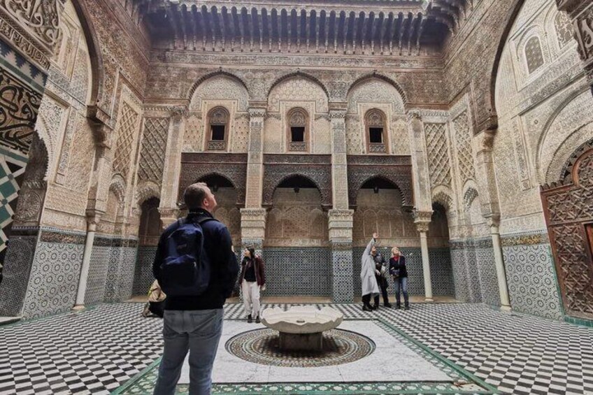 An ornate courtyard with intricate tile work and arches. 5