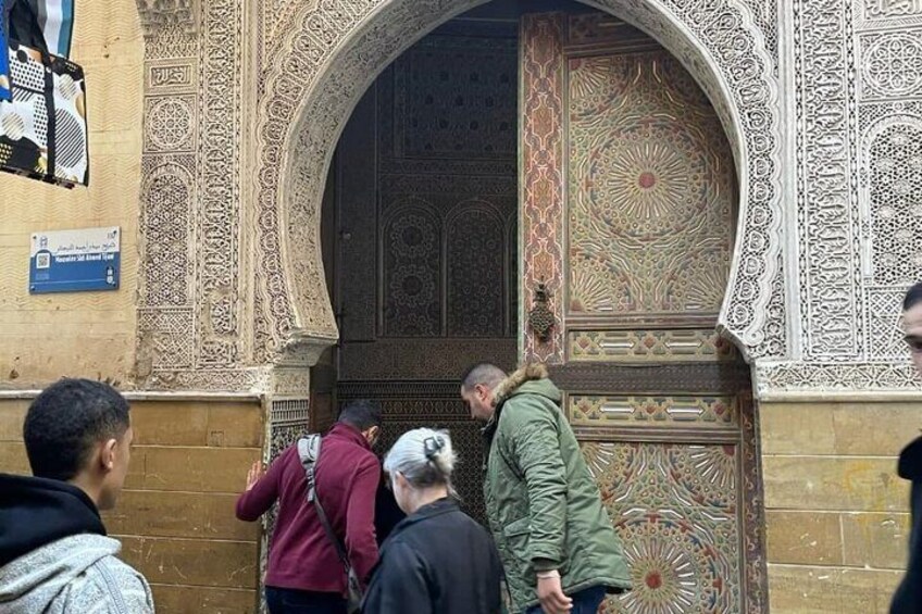 A historic building entrance with ornate carvings and a large, decorative door. 4