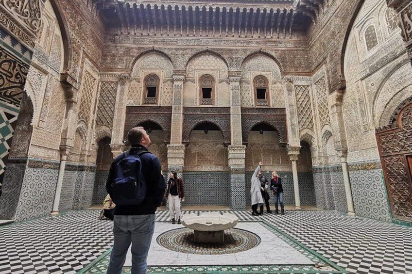 A courtyard with intricate tile work, arches, and a fountain. 4