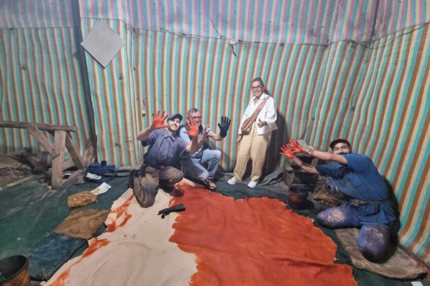 A group of people in a tented area with a large tarp on the floor. 4