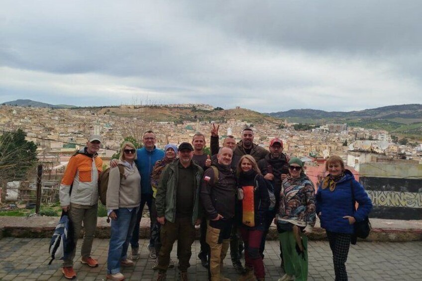A group of people standing on a rooftop with a cityscape in the background. 3