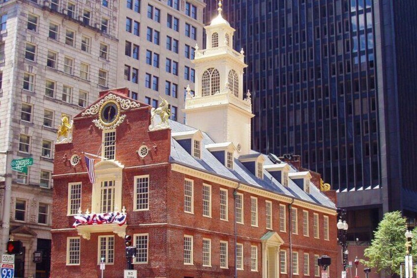 A historic building with a clock tower, a flag, and a sign that reads 'SAVINGS.' 5