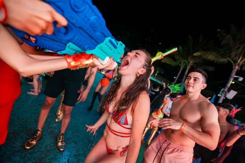 People at a poolside party with water guns and drinks. 4