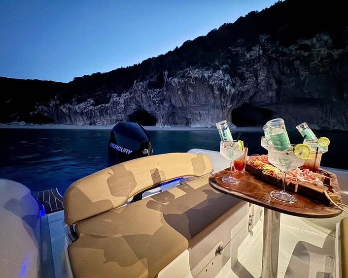 A boat with a table set for a meal, surrounded by a rocky coastline. 5