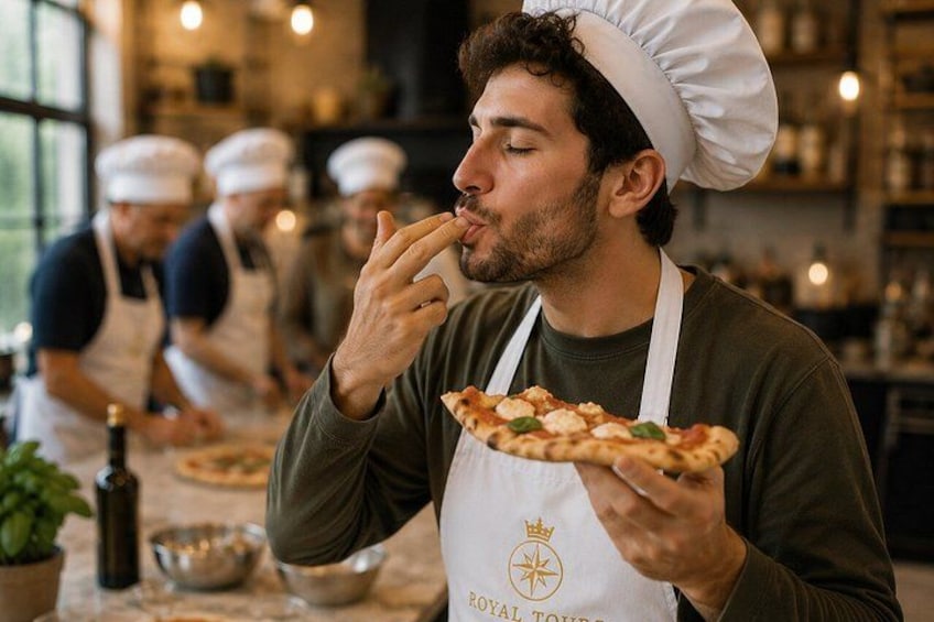 A chef holding a pizza in a kitchen with other chefs in the background. 3