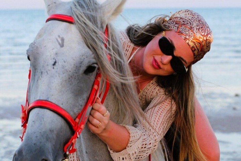 A person with a horse by the sea. 1