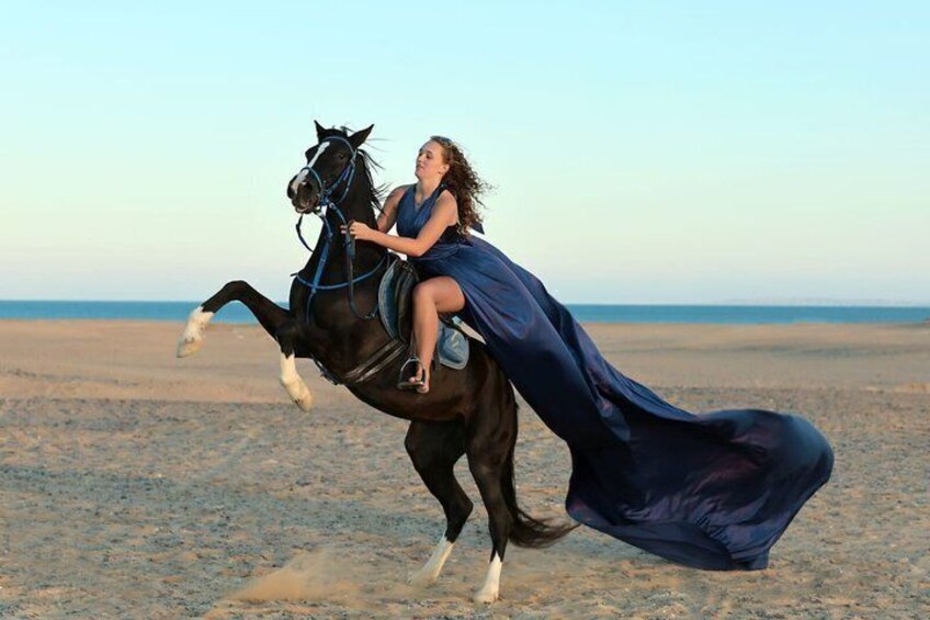 A woman riding a horse on a beach. 1