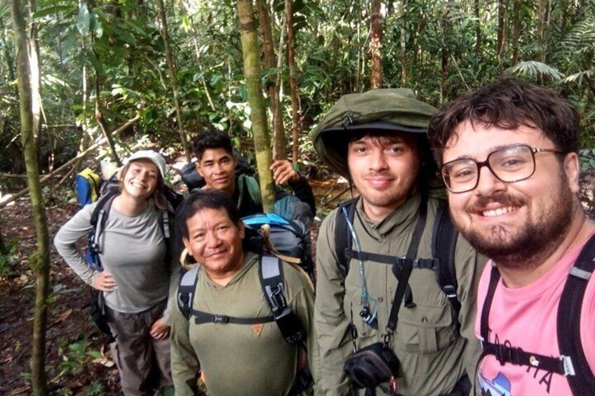 A group of people in a forested area with backpacks, suggesting a hiking or outdoor excursion. 3