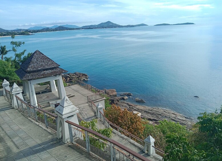 A coastal overlook with a gazebo, a rocky shoreline, and distant mountains. 4