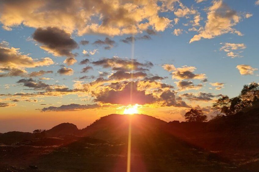 Un atardecer sobre un paisaje montañoso con nubes dispersas. 4