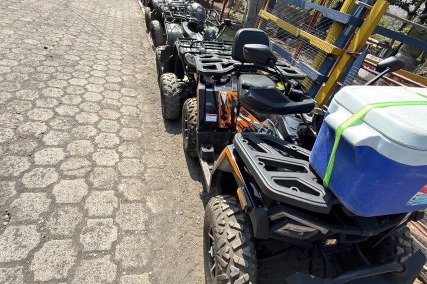A row of ATVs parked on a cobblestone surface. 4