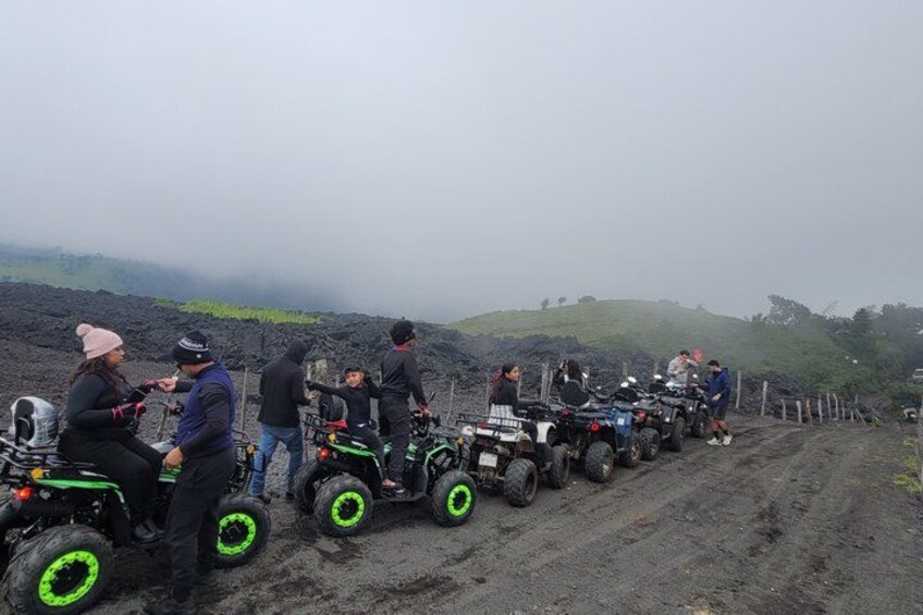 Un grupo de personas en vehículos todo terreno por un camino de tierra, con un paisaje montañoso al fondo. 2