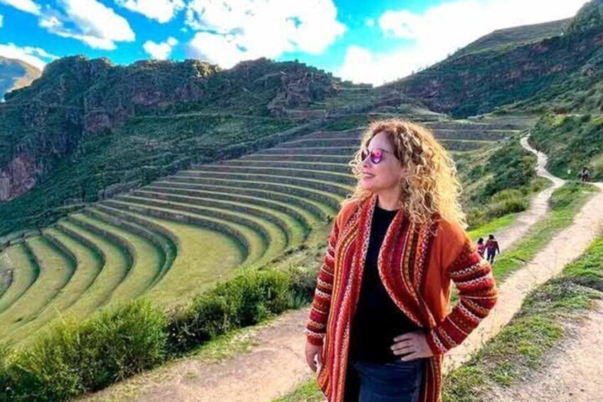 A person standing on a path with terraced fields in the background. 1