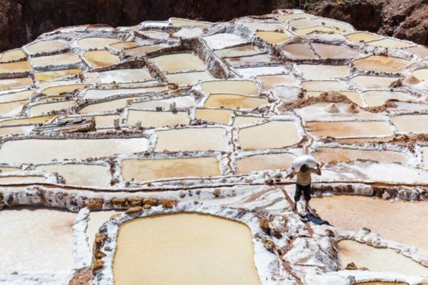 Terraced salt flats with a person standing on the edge. 5