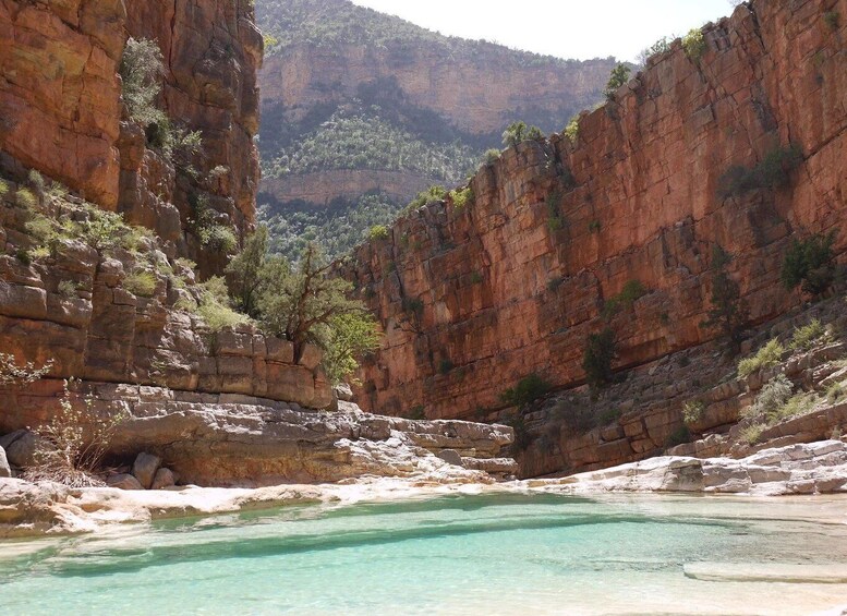 A canyon with clear turquoise water and rocky cliffs. 5