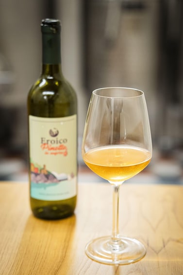 A bottle of wine and a wine glass on a wooden surface. 4