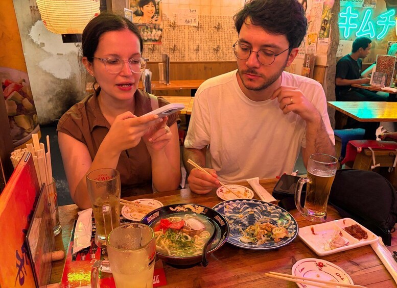 A restaurant interior with tables, dishes, and a neon sign. 5