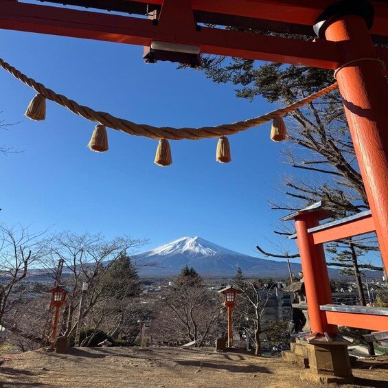 A traditional Japanese torii gate, a snow-capped mountain in the background, and a clear blue sky. 3