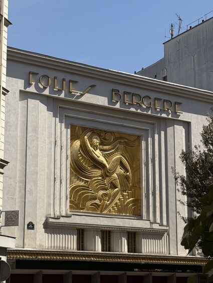 A building facade with the inscription 'FOLIE BERGER' and a relief sculpture of a figure. 2