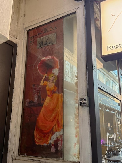 A vintage poster of a woman in an orange dress on a building facade. 4