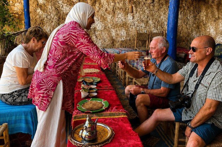 A dining table with plates, a teapot, and a person serving food. 2