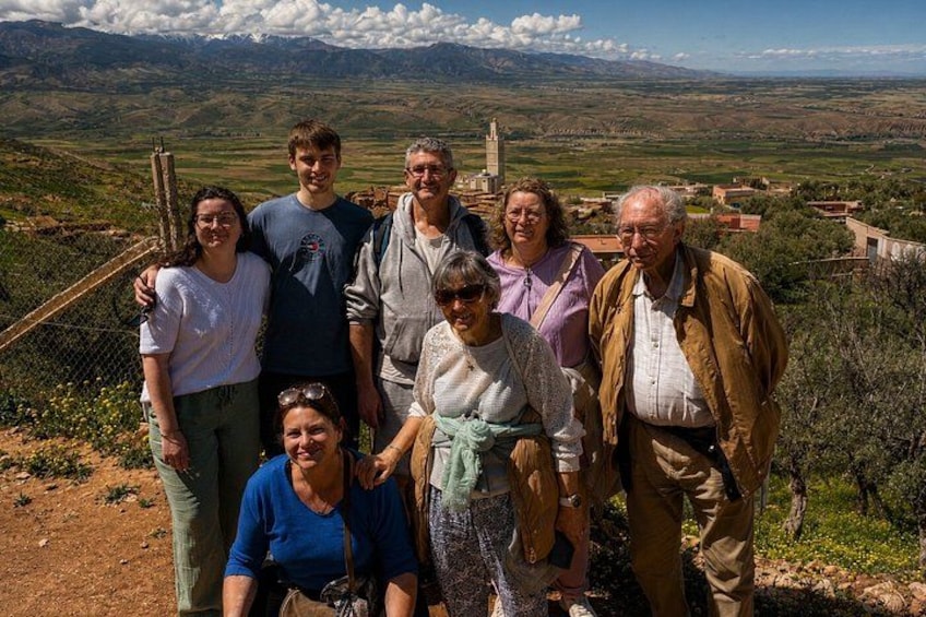 A group of people standing on a hill with a mountainous landscape in the background. 5