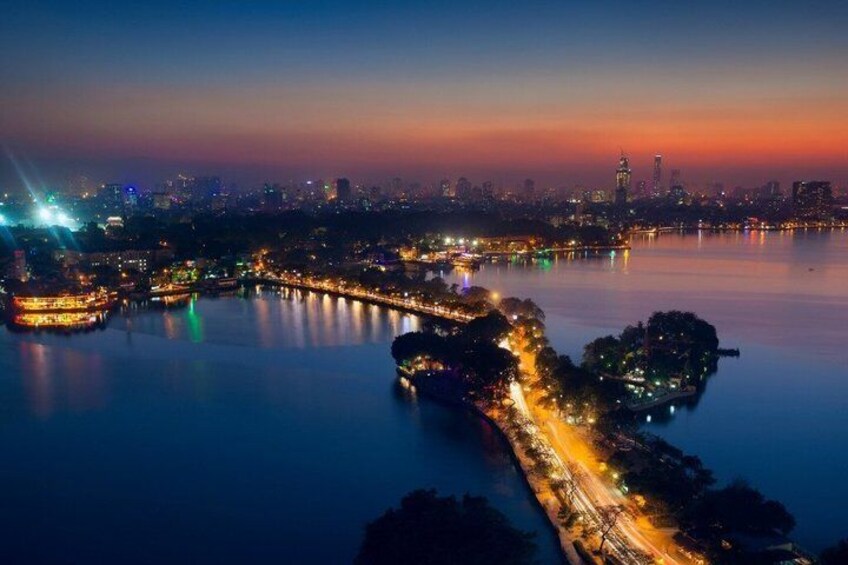 A cityscape at dusk with illuminated bridges and a calm river. 4
