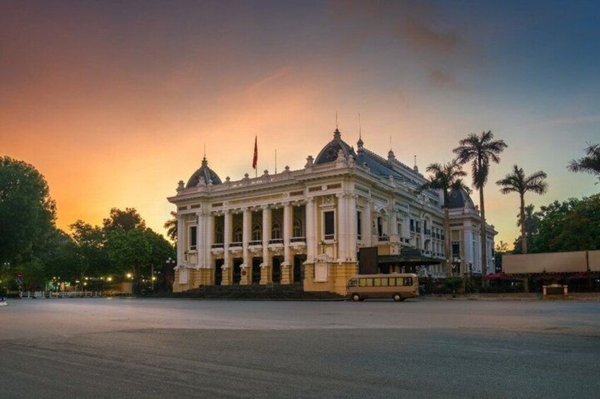 A historic building with columns and a dome, surrounded by palm trees and a sunset sky. 2