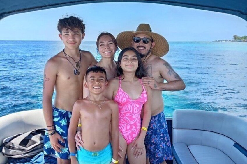 A group of people on a boat with a clear blue sea and a distant shoreline in the background. 2