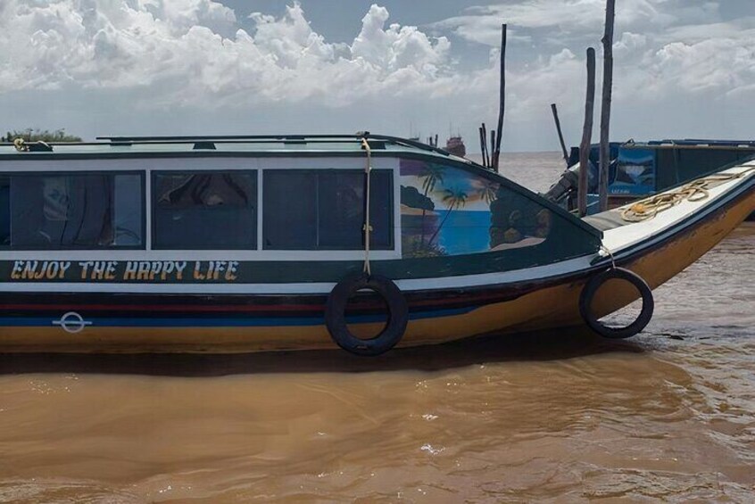 A boat with 'ENJOY THE HAPPY LIFE' written on its side, floating in a body of water. 5