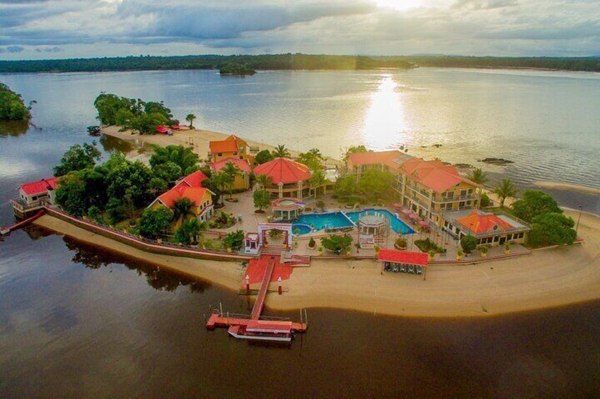 A coastal resort with multiple buildings, a swimming pool, and a dock. 2