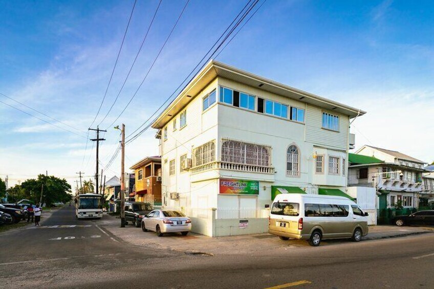 A street with buildings, parked cars, and a bus. 3