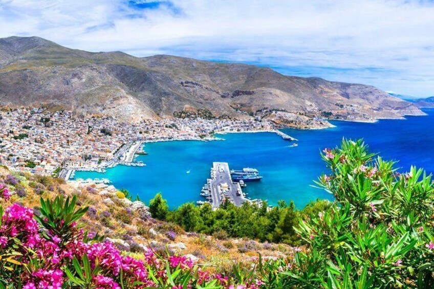 A coastal town with a marina, mountains in the background, and blooming flowers in the foreground. 2
