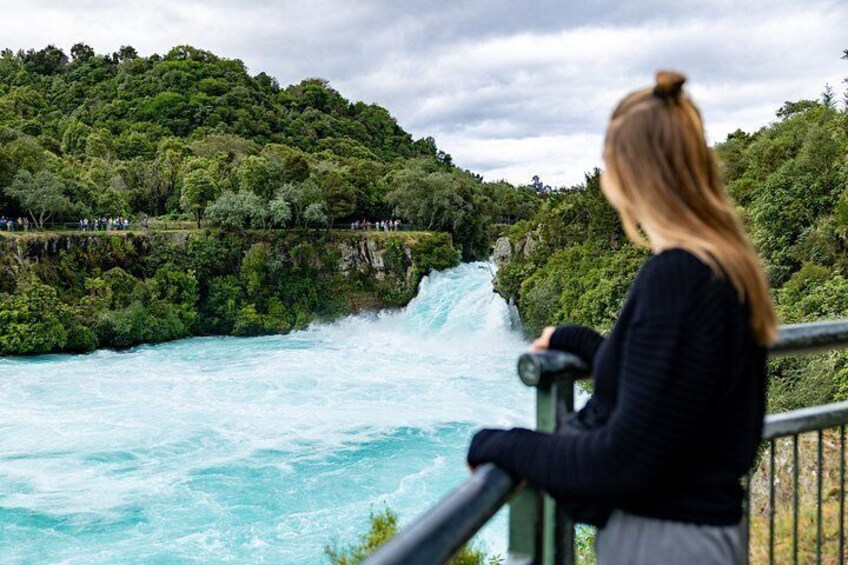 A waterfall, lush greenery, and a person observing the scene. 5