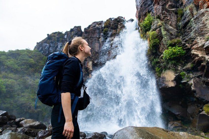 A waterfall, a person with a backpack, and rocky terrain. 3