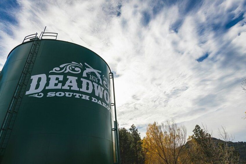 A large green water tower with the text 'DEADWOOD SOUTH DAR' and a ladder on top. 2