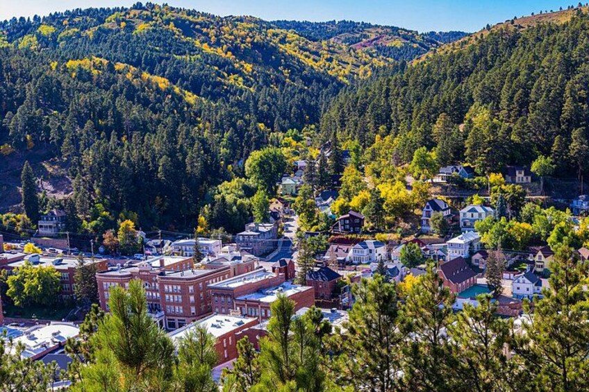 A town nestled in a valley with a backdrop of forested hills. 3