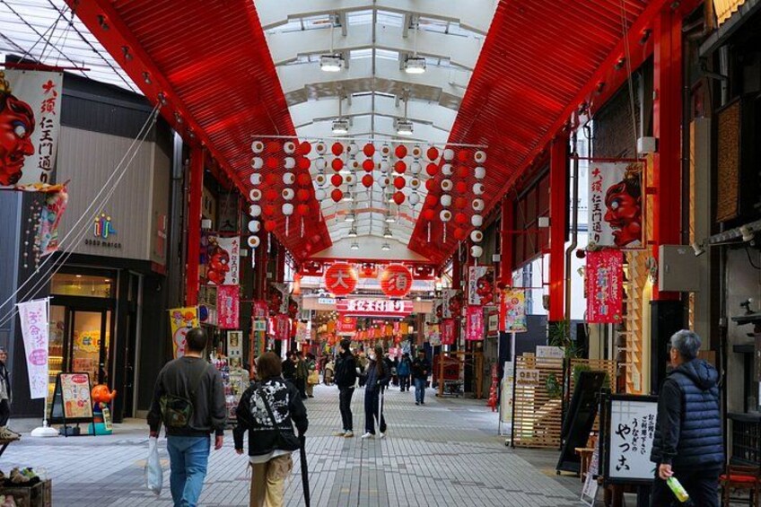 A bustling indoor market with red lanterns and signs. 5