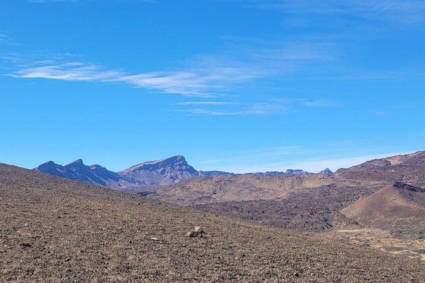 A barren landscape with distant mountains under a clear sky. 5