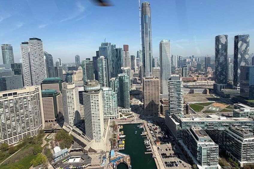 A cityscape with modern high-rise buildings, a river, and a bridge. 1