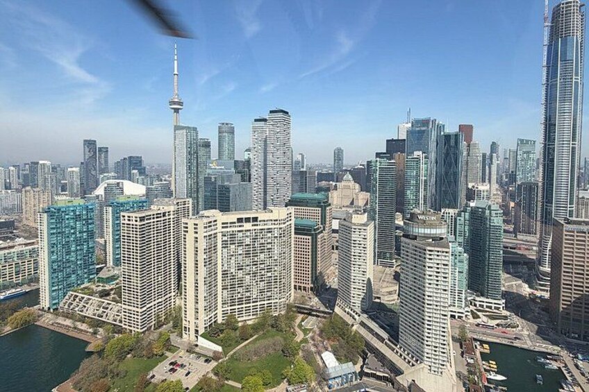 A cityscape with high-rise buildings, a prominent tower, and a body of water. 5