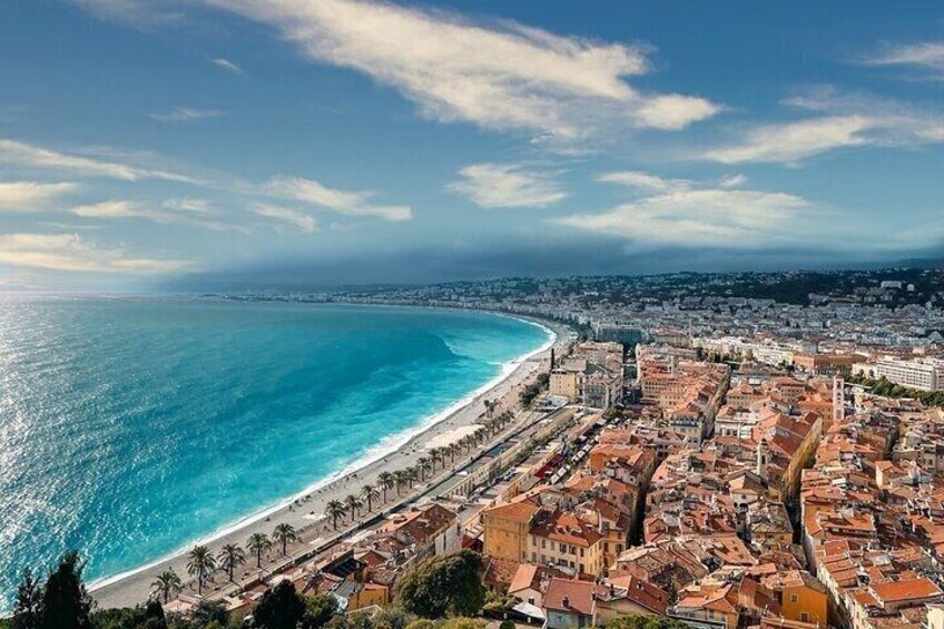 A coastal cityscape with a beach, buildings, and a clear sky. 1
