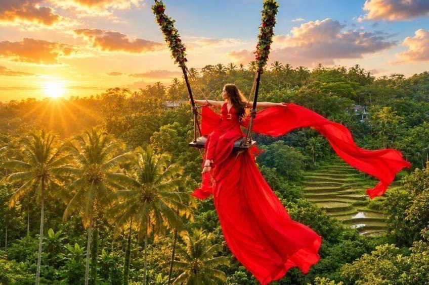 A person in a red dress swinging on a swing with a lush green landscape and palm trees in the background. 1