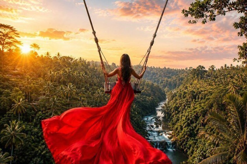 A person in a red dress swinging on a swing over a river surrounded by lush greenery. 2