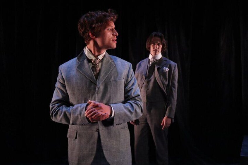 Two men in suits on a stage. 4